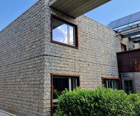 Würfelförmiges Haus mit Gabionenverkleidung